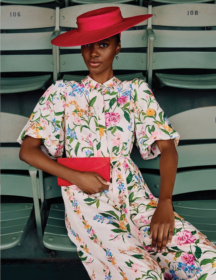Woman wearing a floral Phase Eight dress with a red wide-brim hat
