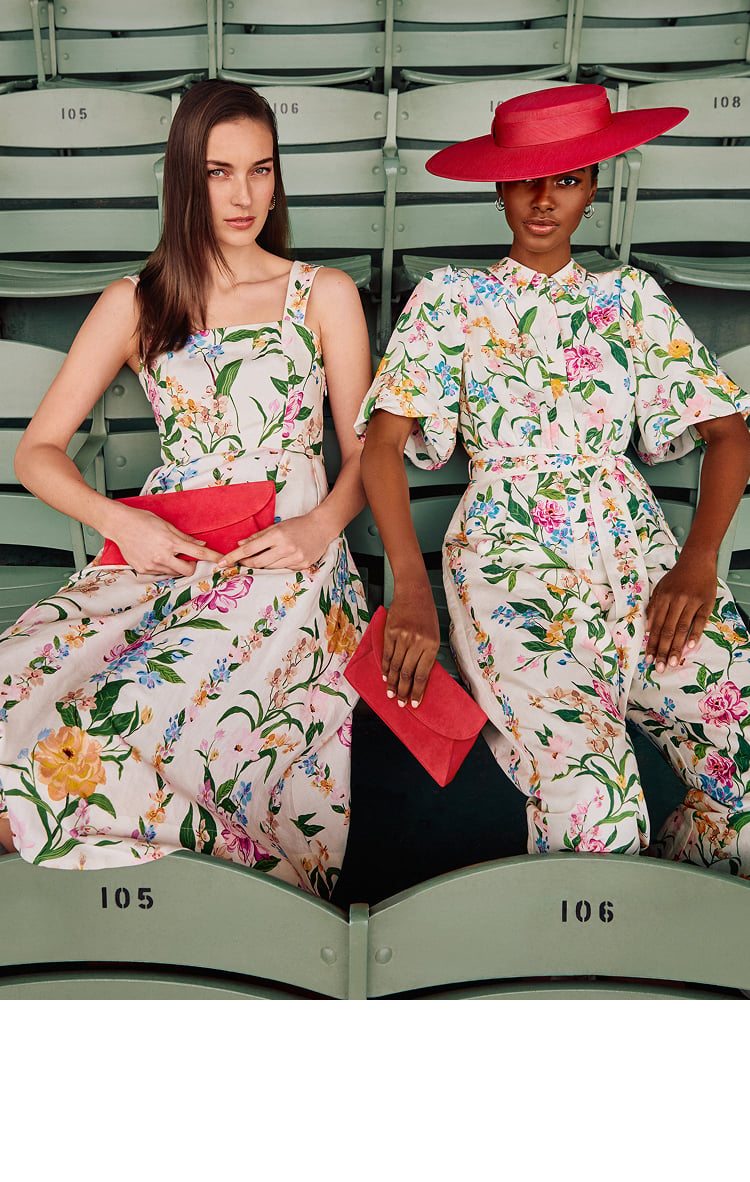 Two women wearing floral Phase Eight dresses with red accessories