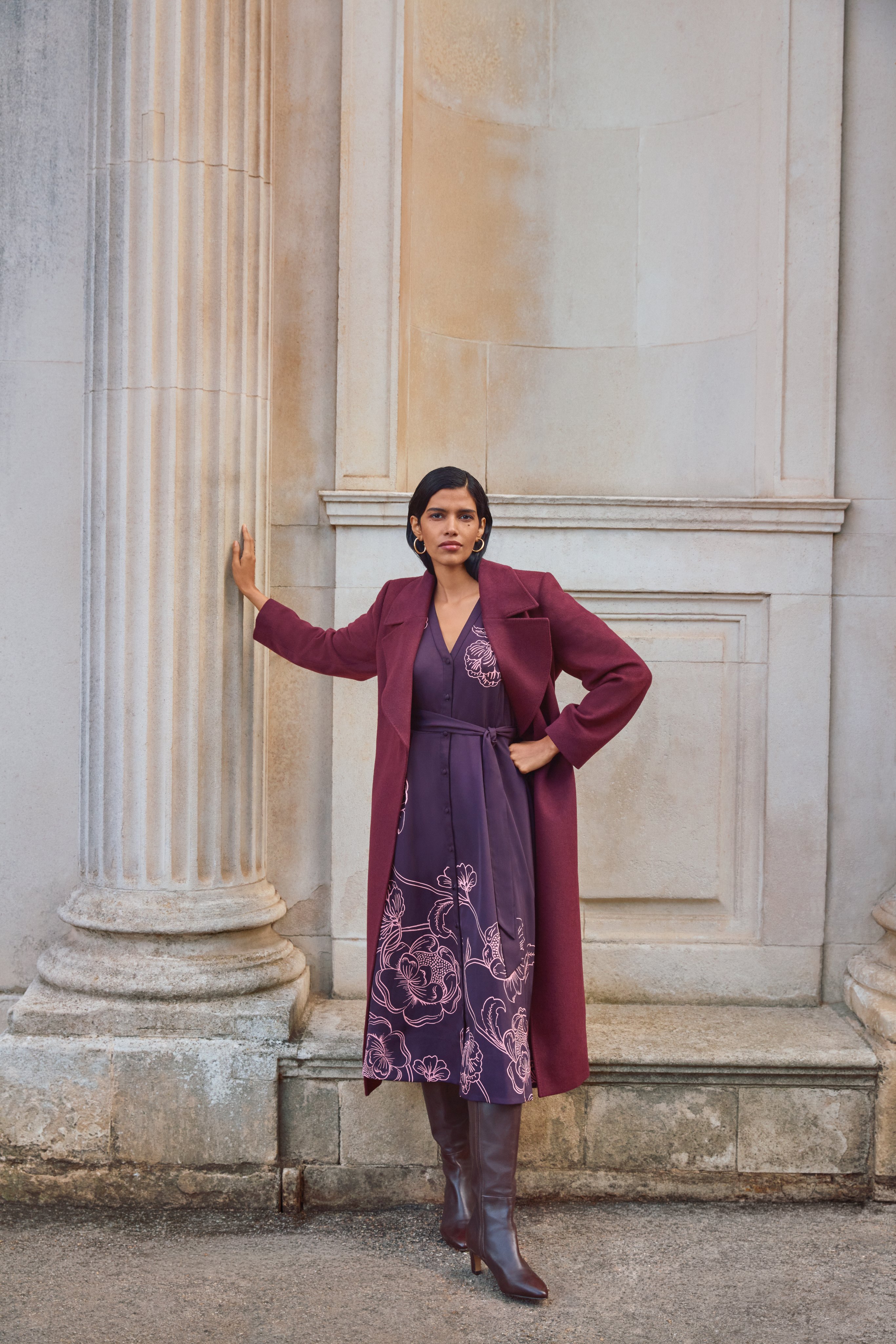A woman wearing the Mabel print dress with the Daisy shawl collar coat.
