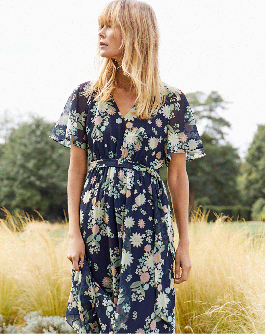 Woman in a sunny field in a floral maxi dress