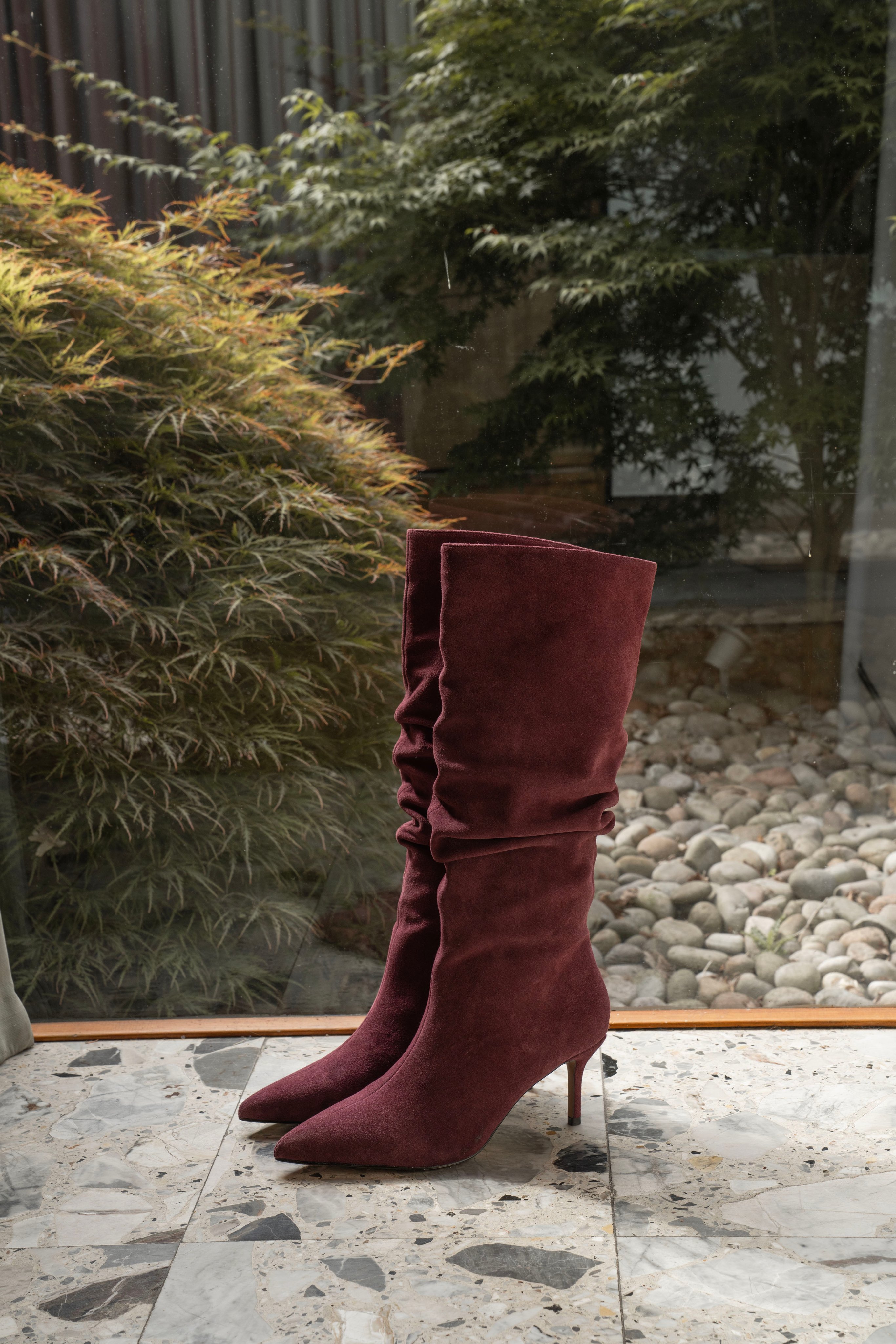 Burgundy suede slouch boots.