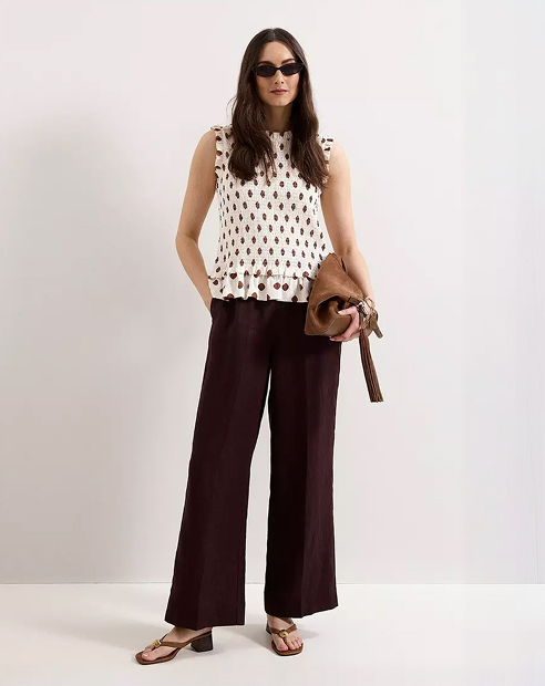 Woman in Phase Eight Polka Dot top and brown trousers