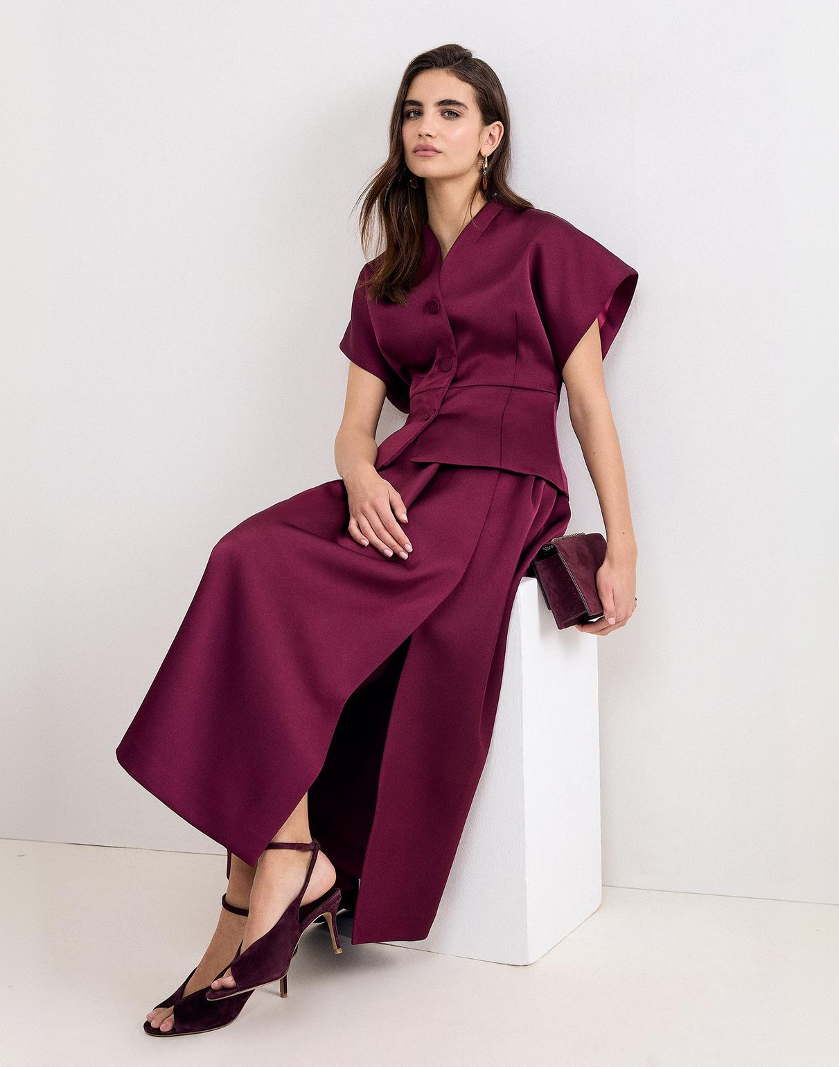 A woman wearing the Sally satin tailored skirt.