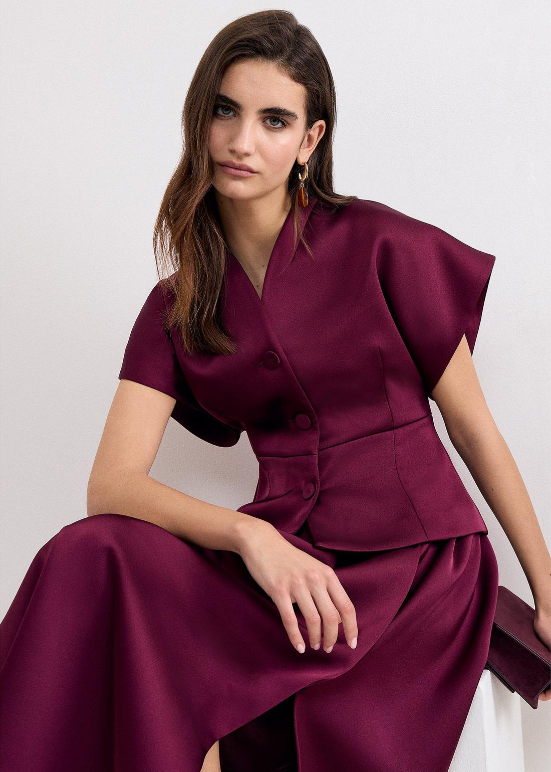 A woman wearing the Sally satin tailored jacket.