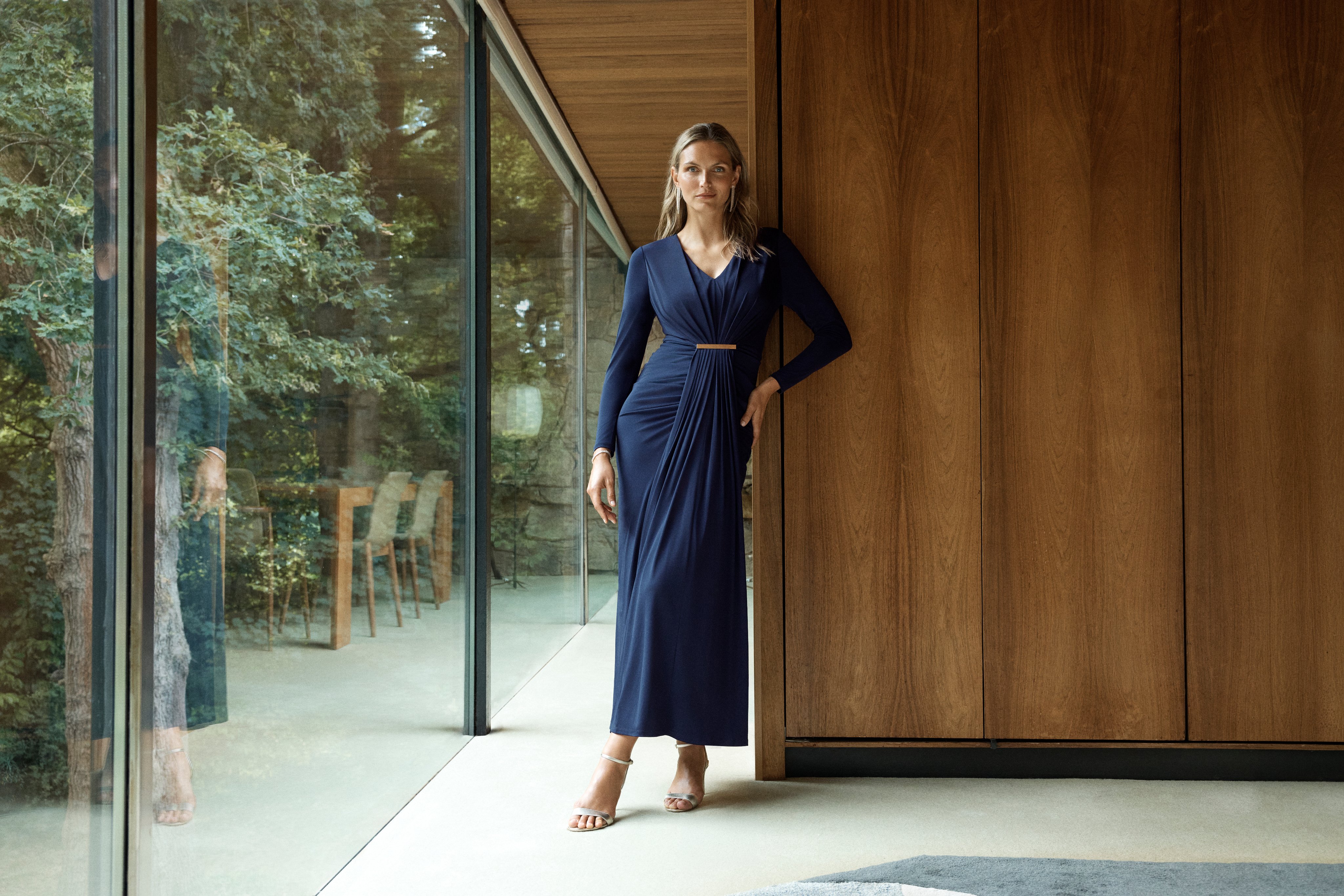 Editorial portrait of a woman wearing a navy maxi dress.