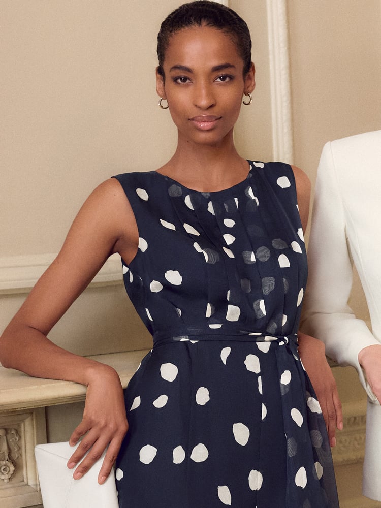 Woman wearing a navy polka dot Phase Eight dress